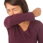 woman coughing into arm