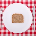Tablecloth with fork, knife and a slice of bread on the plate